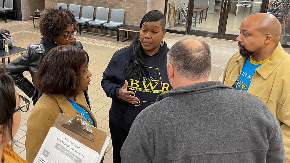 A group of people stand outside county jail before helping people in jail register to vote